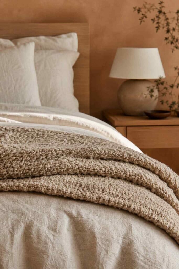 Space-Saving 15 Minimalist Bedroom Ideas for a Calm, Clutter-Free Retreat in 2026 3 Close-up of folded linen bedding and wool throw texture in a warm minimalist bedroom idea.