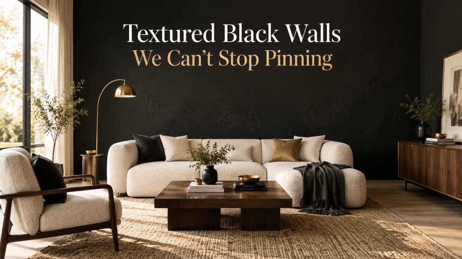 Textured matte black accent wall behind a bouclé sofa in a modern living room with brass accents.