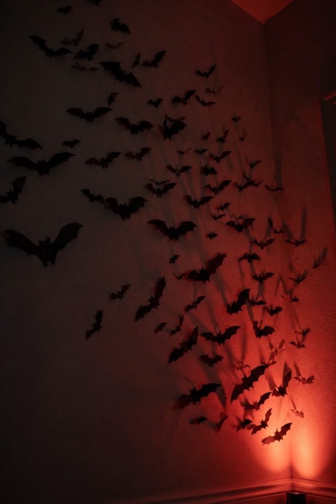 28 Halloween Party Decorations Scary Enough to Terrify Every Guest 9 Swarm of black paper bats across a wall as a scary Halloween party decoration.
