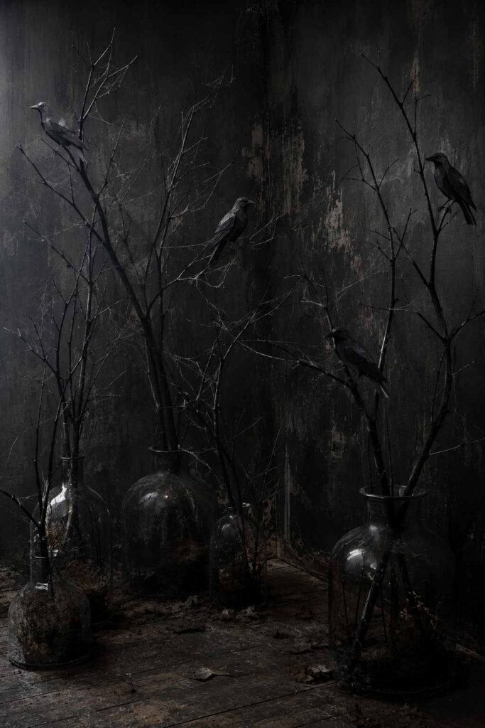 28 Halloween Party Decorations Scary Enough to Terrify Every Guest 12 Tall black branches in vases with paper ravens in a corner as spooky Halloween party decor.