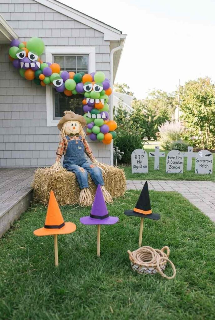 Backyard Halloween setup with scarecrow, witch hat ring toss and foam tombstones for kids.