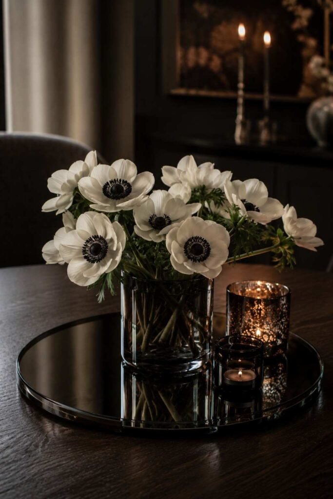 27 Chic Mirror Table Decor with Fresh Flowers Ideas for Home, Weddings, and Parties 19 White anemones with dark centers on a smoked mirror tray under dim candlelight